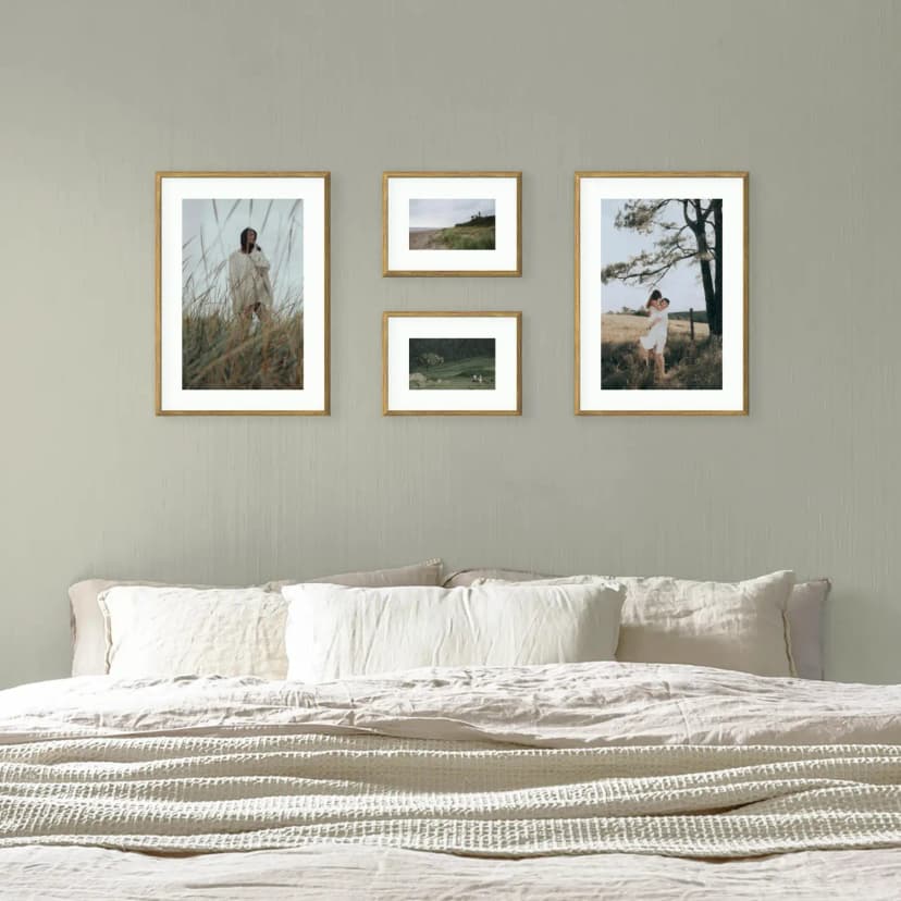 Beautiful [bedroom gallery wall](/en-gb/photo-gallery-walls/bedroom) with framed photos above bed