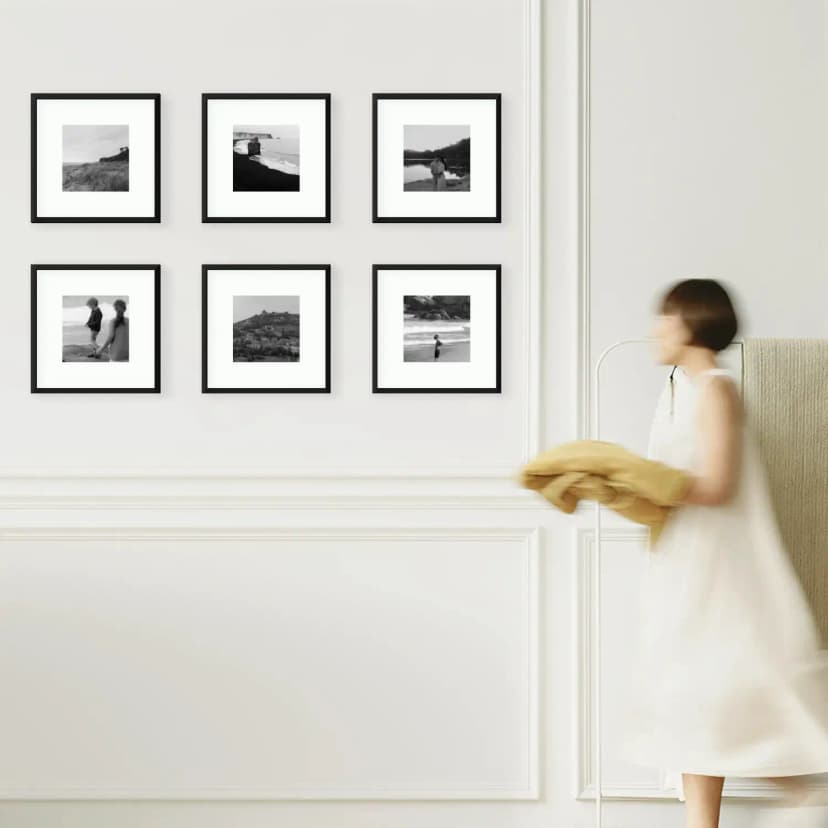 Woman walking past elegant black and white photo gallery in hallway corridor