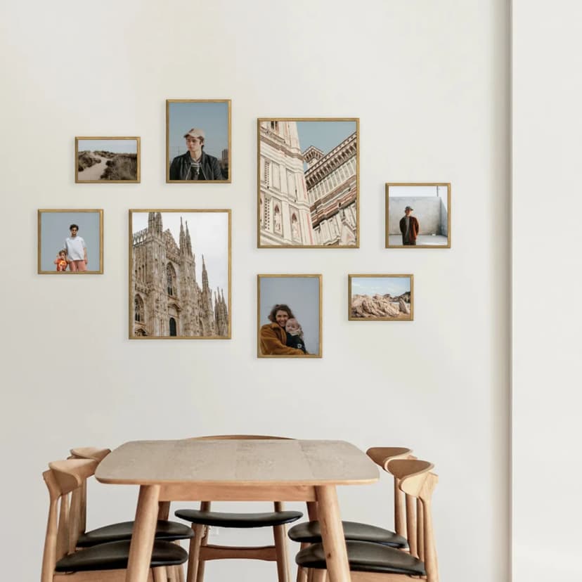 Large gallery wall with mixed-sized frames arranged in a cohesive layout above a white sofa