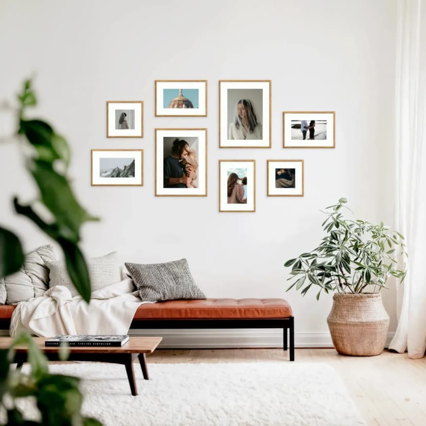 Asymmetrical gallery wall with frames arranged in flowing, natural pattern above modern seating