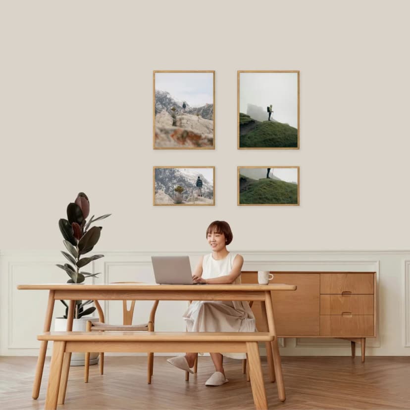 Gallery wall arranged in horizontal tiers with varied frame sizes within each row creating balanced composition