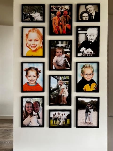 Close-up of a family photo gallery with black frames